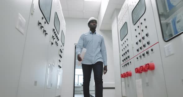 Portrait of an Engineer in a Hard Hat at the Production Blueprint in Hands