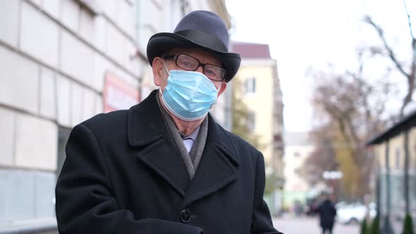 Portrait of an Old Elderly Man with a Blue Mask on His Face He Looks at the Camera
