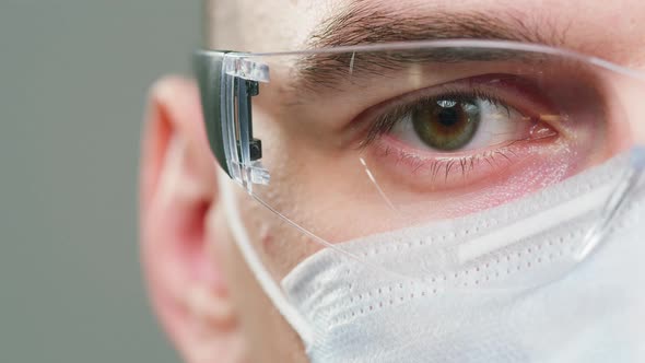 Closeup of Doctor Scientist Specialist Wearing Medical Protective Glasses and Mask Halfface Portrait