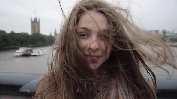 Woman takes a selfie during a windy day in London