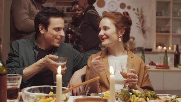 Young Couple Chatting and Flirting at Home Dinner Party with Friends