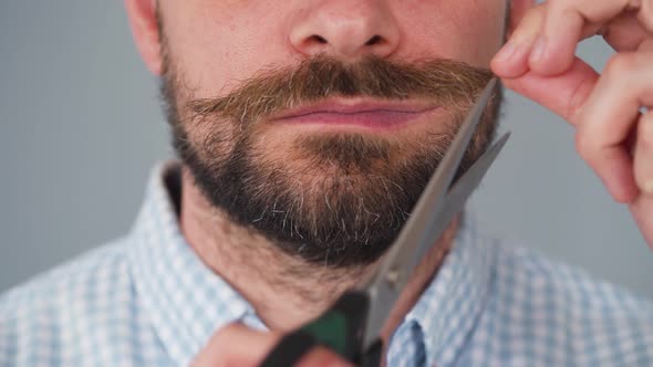 Bearded Man Twists His Mustache and Cuts It Off with Scissors