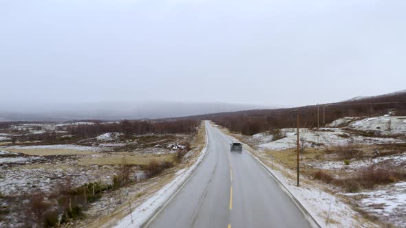 Vehicle Driving On Countryside Road Of Dovre, Innlandet County, Norway During Winter - aerial drone