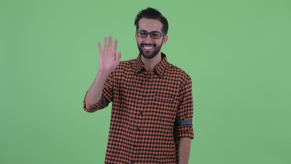 Happy Young Bearded Persian Hipster Man Waving Hand