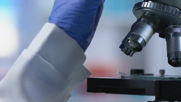 Laboratory Worker Carefully Examining Sample Under Microscope, Medical Research