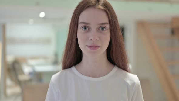 Portrait of Redhead Young Woman Pointing Finger and Inviting