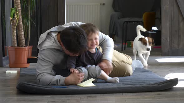 Father with a son and dog is working at home