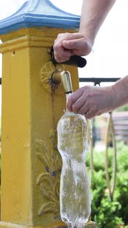 A man draws water from an  drinking spring.