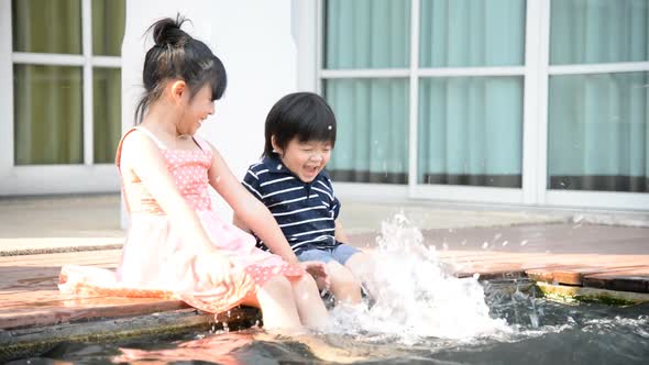 Asian Children Splashing Around In The Pool