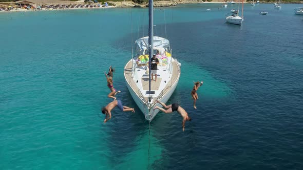 Aerial view of friends jumping from boat, mediterranean sea, Vathi, Greece.