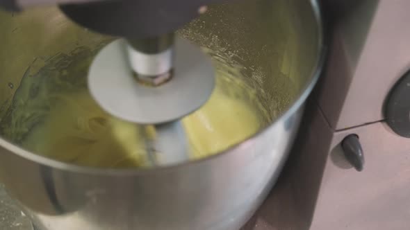 Modern appliance mixing dough in kitchen