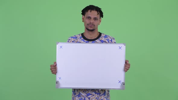 Stressed Young African Man Holding White Board