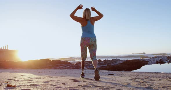 Disabled woman exercising in the beach at dusk 4k