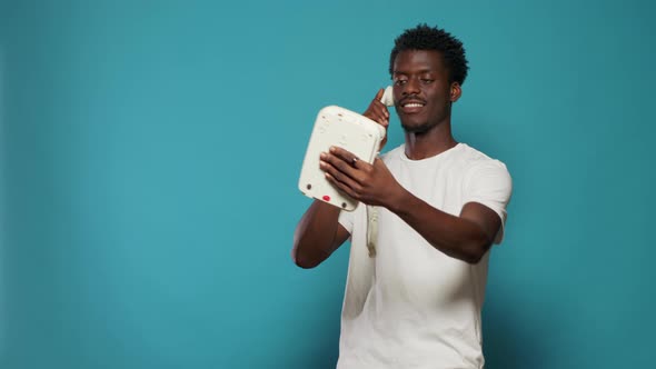 Playful Man Joking About Taking Selfies with Retro Landline Phone