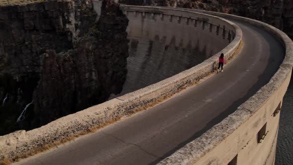 Aerial of a woman hiking across the Salmon Falls Dam in Southern Idaho