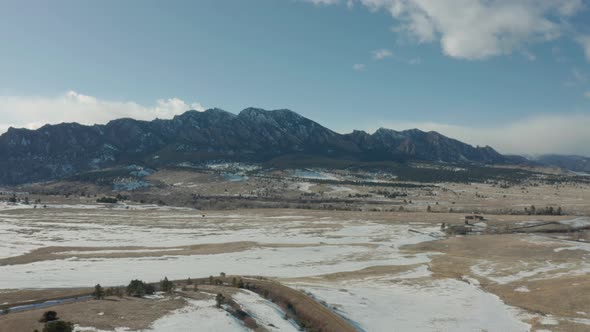Aerial Drone Shot Over Snowy Colorado Plains With Front Range In Background