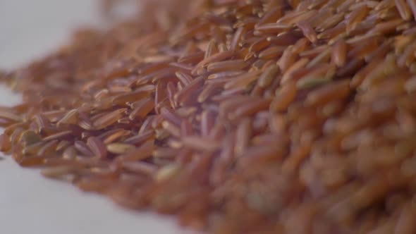 Heap of Red Rice Close Up Pouring Down. Red Rice Closeup. Slow Motion. Food Video