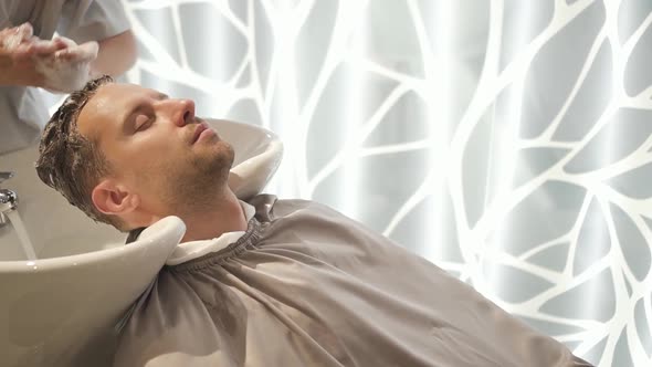 Calm Costumer Enjoy Hair Washing in Barber Shop