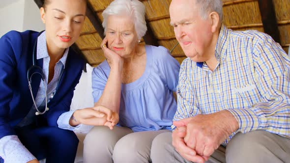Front view of Caucasian female doctor discussing medication with senior couple at comfortable home 4