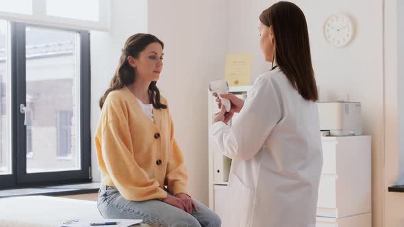 Doctor with Thermometer and Woman at Hospital