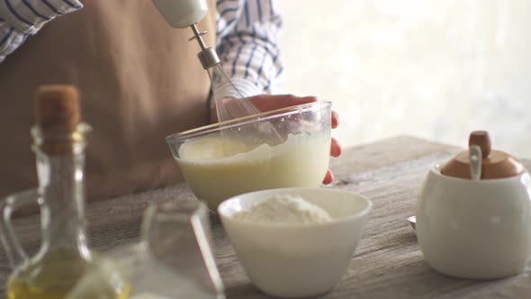 Girl Chef Whips Yellow Eggs With A Blender Whisk Mixer For Cooking.