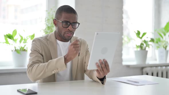 African Man Making Video Call on Tablet in Office