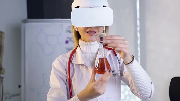 Female Doctor Scientist in Virtual Reality Glasses Uses Test Tube with Liquid 