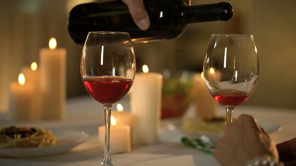 Man Pouring Wine and Toasting, Married Couple Celebrating Anniversary Restaurant