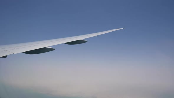 an Airplane Wing with the Clouds. Cargo and Passenger Air Transportation. Air Flight