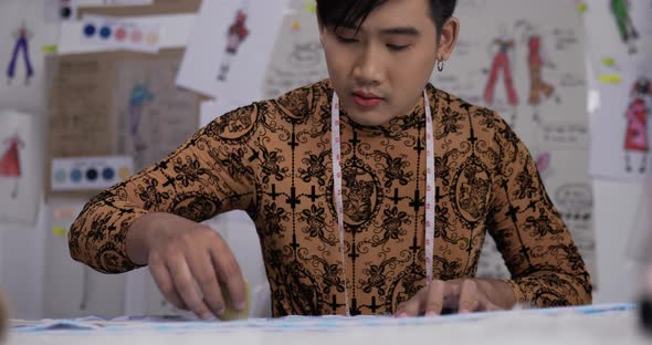 Fucused fashion designer man sewing in studio