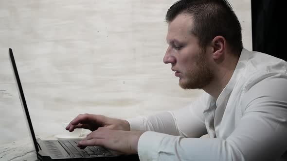 Freelancer In A White Shirt With A Cup Of Coffee Typing Text On A Computer Keyboard