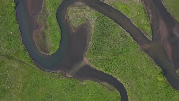 View From the Drone Vertically Down to the Green Fields and the River