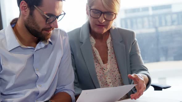 Businesspeople looking at document