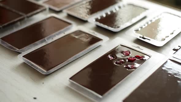 The melted chocolate mass is poured into bar molds.