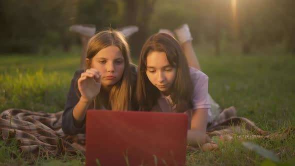 Two Positive Teenage Girls Closing Laptop Running Away Leaving in Golden Sunshine in Slow Motion