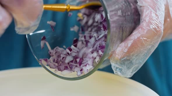 The Chef Pours From a Transparent Glass Red Chopped Onion to Potato Salad