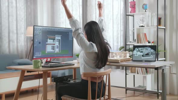 Asian Woman Engineer Celebrating While Designing House On A Desktop At Home