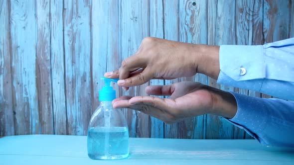 Businessman Using Sanitizer Gel on on Office Desk 