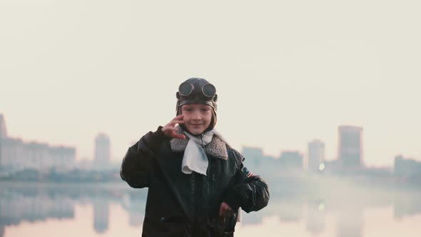 Beautiful Portrait of Little Girl in Old Pilot Costume on Sunset Near Amazing City Lake