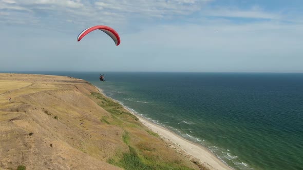Person Is Paragliding Near the Sea, Landscape View, Extreme Sports