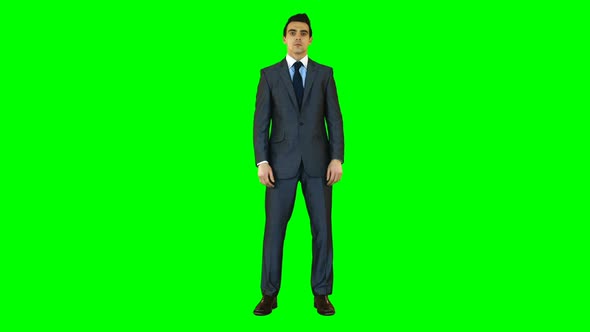 Businessman standing against green background