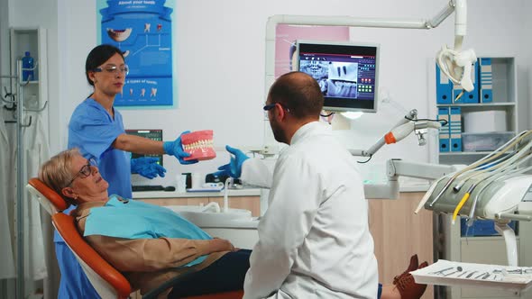 Stomatologist Explaining Dental Hygiene Using Dental Skeleton