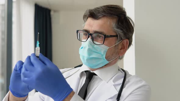 Senior Male Doctor Preparing Vaccination Syringe