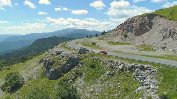 Car Passing Another One While Turning on Mountain Road