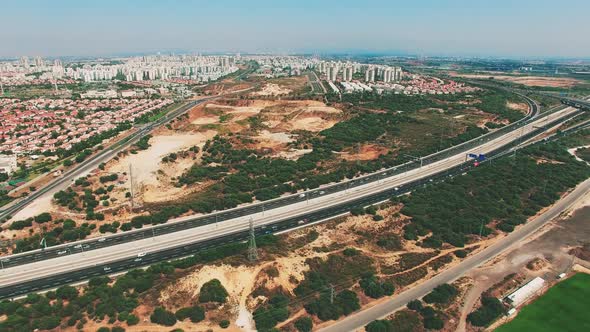 Aerial of a freeway with city background.