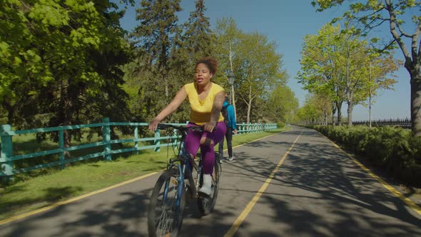 Positive Lovely African American Woman Cycling Through Public Park