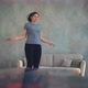Stylish Lady Jumps Rope Training Near Sofa in Living Room - VideoHive Item for Sale