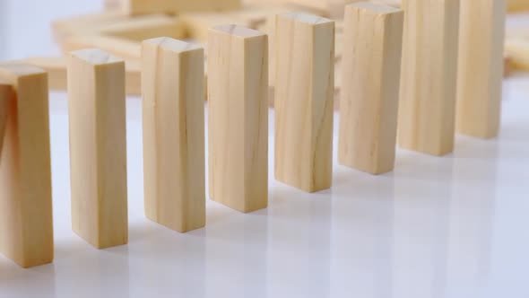 Domino Effect Row of Wooden Domino Falling Down on White Background