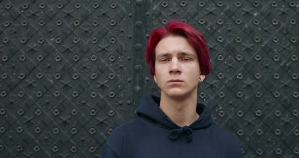 Portrait of Young Hipster Man with Dyed Red Hair Turning Head and Looking To Camera. Close Up of