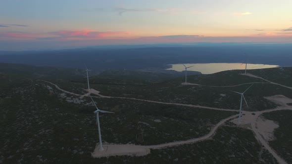 Aerial view of five windmills for the production of electric energy, at sunset